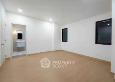 Spacious unfurnished room with wooden flooring and attached bathroom, ideal for customization.