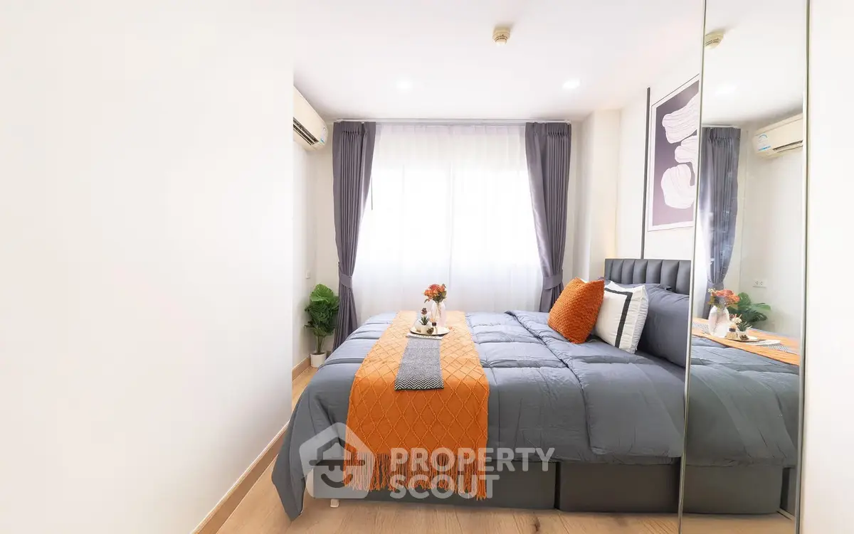 Modern bedroom with stylish decor and natural light, featuring a cozy bed and elegant curtains.