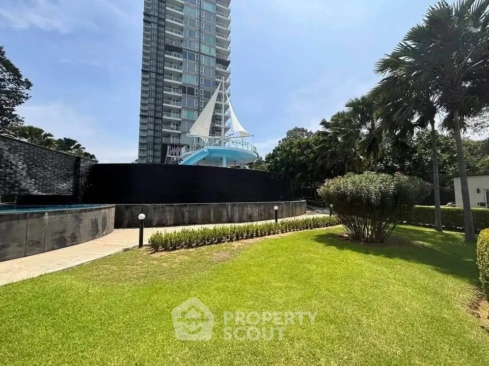 Luxurious high-rise building with lush green garden and unique architectural design.