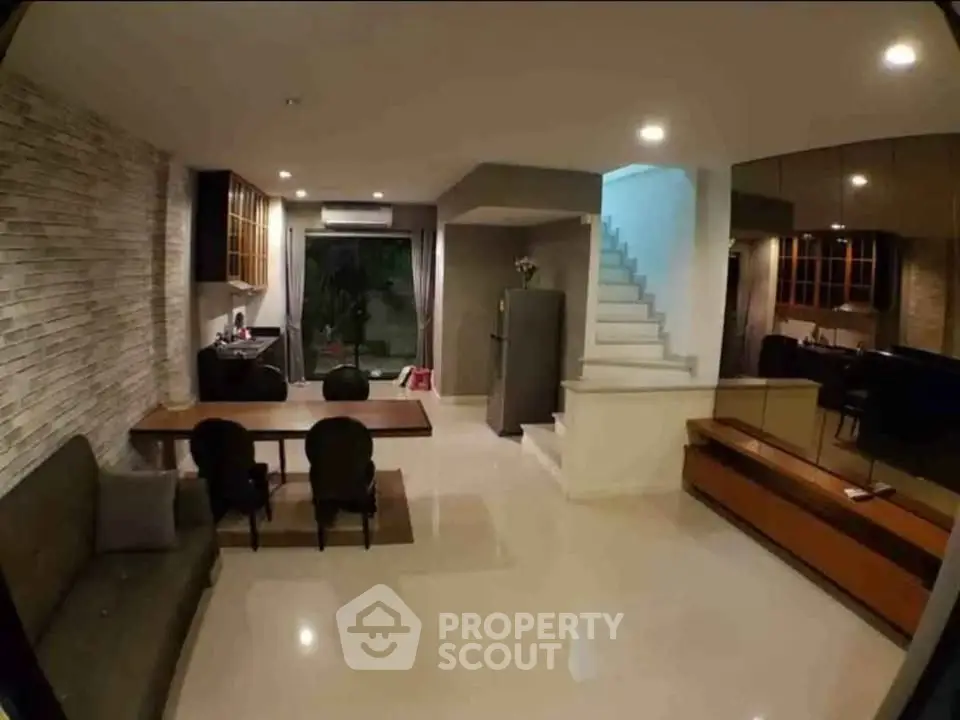 Spacious modern living room with dining area and staircase in elegant home