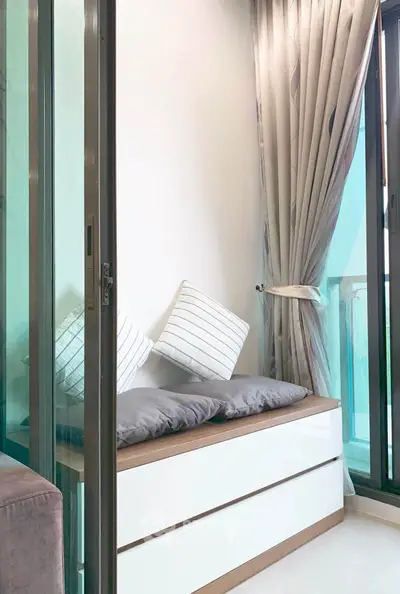 Cozy corner with stylish seating and modern sliding glass doors in a bright apartment.