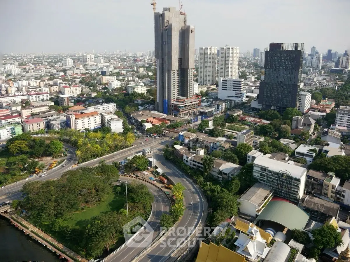 Stunning aerial view of urban skyline with high-rise buildings and lush greenery, showcasing city development.