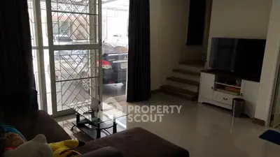 Cozy living room with modern decor and large window view of parked cars.