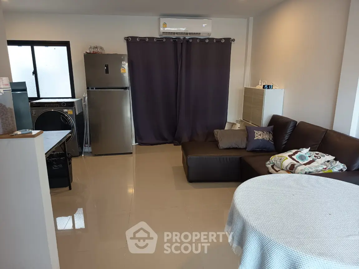 Modern living room with sleek furniture and appliances, featuring a cozy sofa and dining area.
