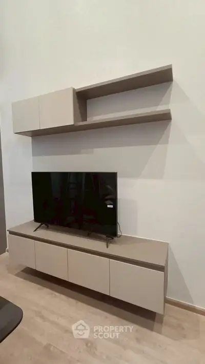 Modern living room with sleek TV unit and floating shelves