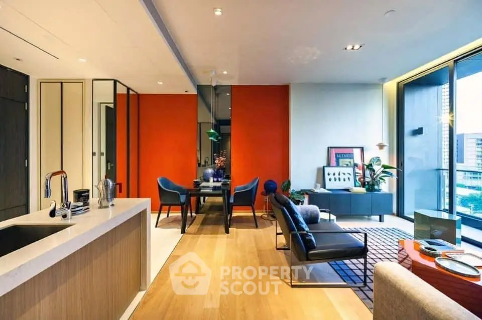 Luxurious modern living room with open kitchen and vibrant decor, featuring floor-to-ceiling windows and stylish furniture.