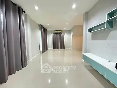 Spacious modern living room with sleek tile flooring and stylish built-in shelves, perfect for contemporary living.