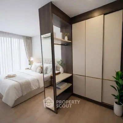 Modern bedroom with elegant decor and ample natural light, featuring a stylish wardrobe and cozy bed.
