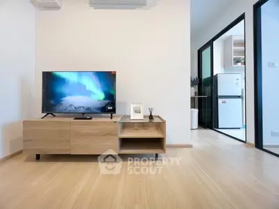 Modern living room with wooden TV stand and open kitchen view