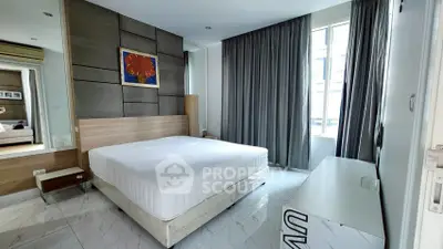 Modern bedroom with stylish decor and large window in a contemporary apartment.