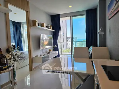 Modern living room with balcony and ocean view, sleek furniture, and stylish decor.