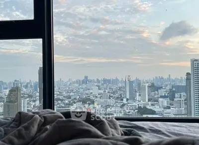 Stunning cityscape view from a cozy bedroom window, perfect urban living.