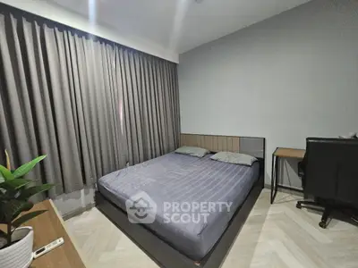 Modern bedroom with sleek design, featuring a comfortable bed and stylish desk, perfect for urban living.