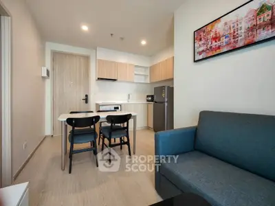 Modern open-plan living room with kitchen, featuring sleek furniture and contemporary decor.