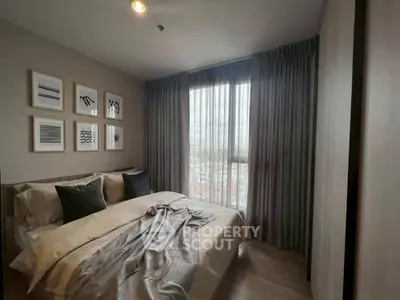 Cozy bedroom with large window and elegant decor, offering a serene ambiance and natural light.