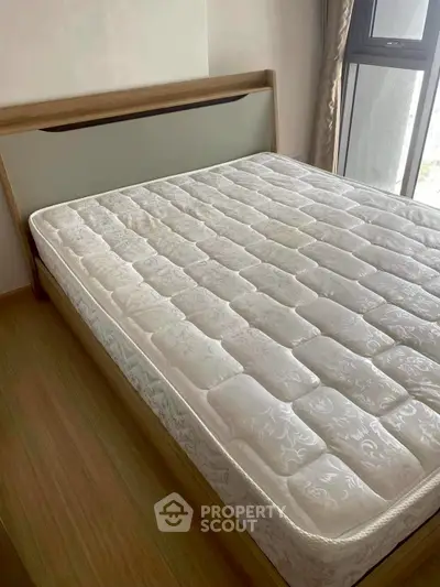 Spacious bedroom with large window and comfortable bed in modern apartment