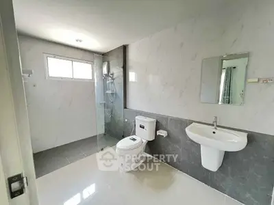 Modern bathroom with sleek design, featuring a glass-enclosed shower and contemporary fixtures.