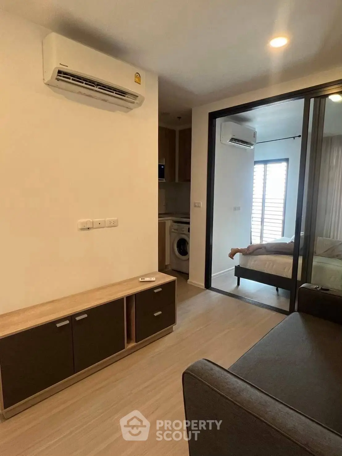 Modern apartment interior with air conditioning and washing machine, featuring a cozy bedroom and stylish living area.