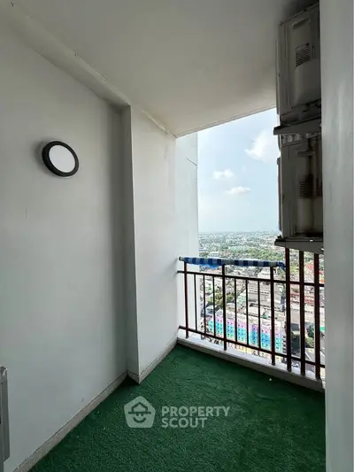 Cozy balcony with city view and artificial grass flooring, perfect for relaxation.