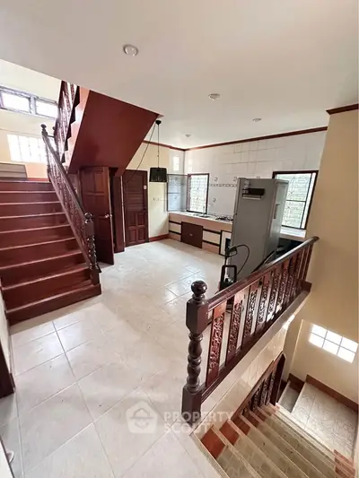 Spacious multi-level home with elegant wooden staircase and modern kitchen.