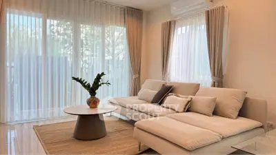 Elegant living room with modern sofa, large windows, and stylish decor, perfect for relaxation and entertaining.