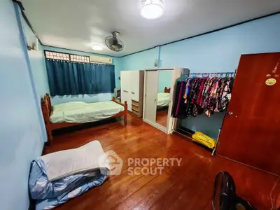 Spacious bedroom with wooden flooring and ample closet space in a cozy home.