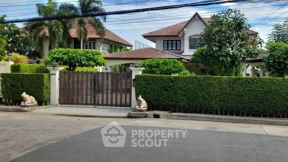 Charming suburban house with lush greenery and gated entrance