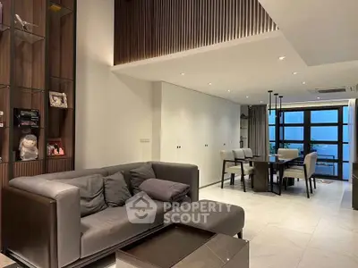 Modern living room with elegant dining area and large windows offering a stunning view.
