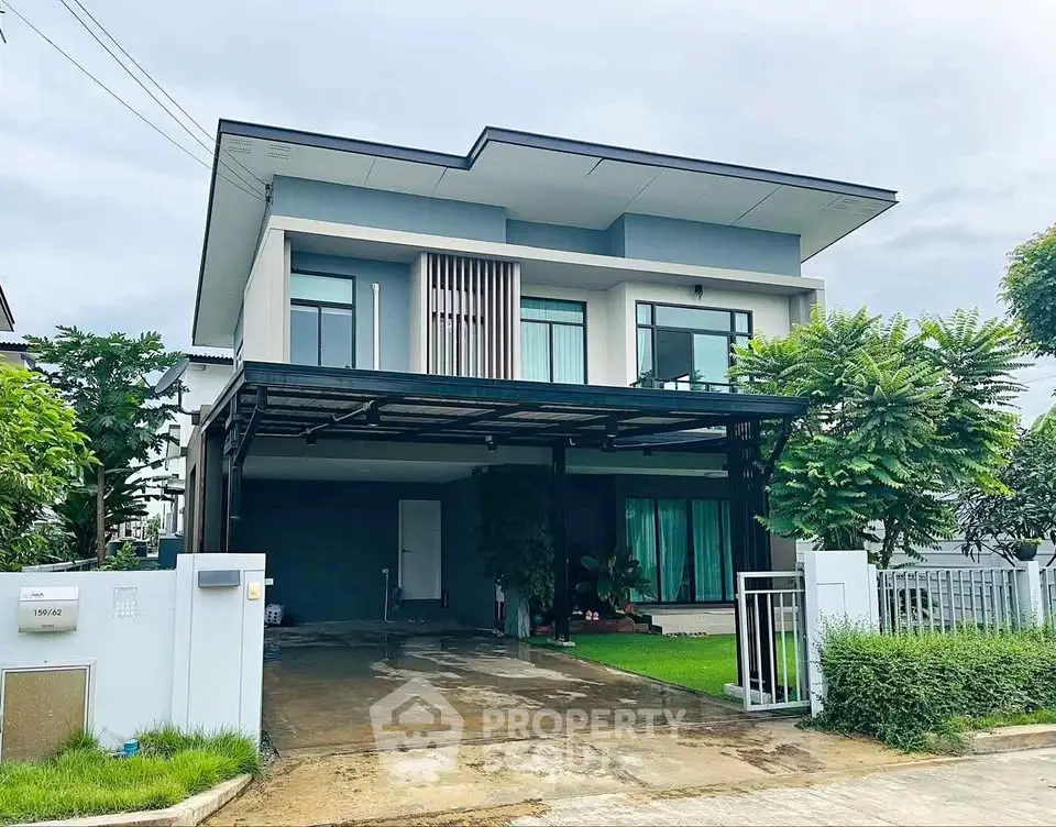 Modern two-story house with sleek design and lush greenery