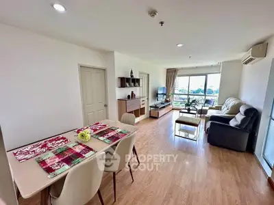Spacious living room with modern decor and large windows offering natural light and scenic views.