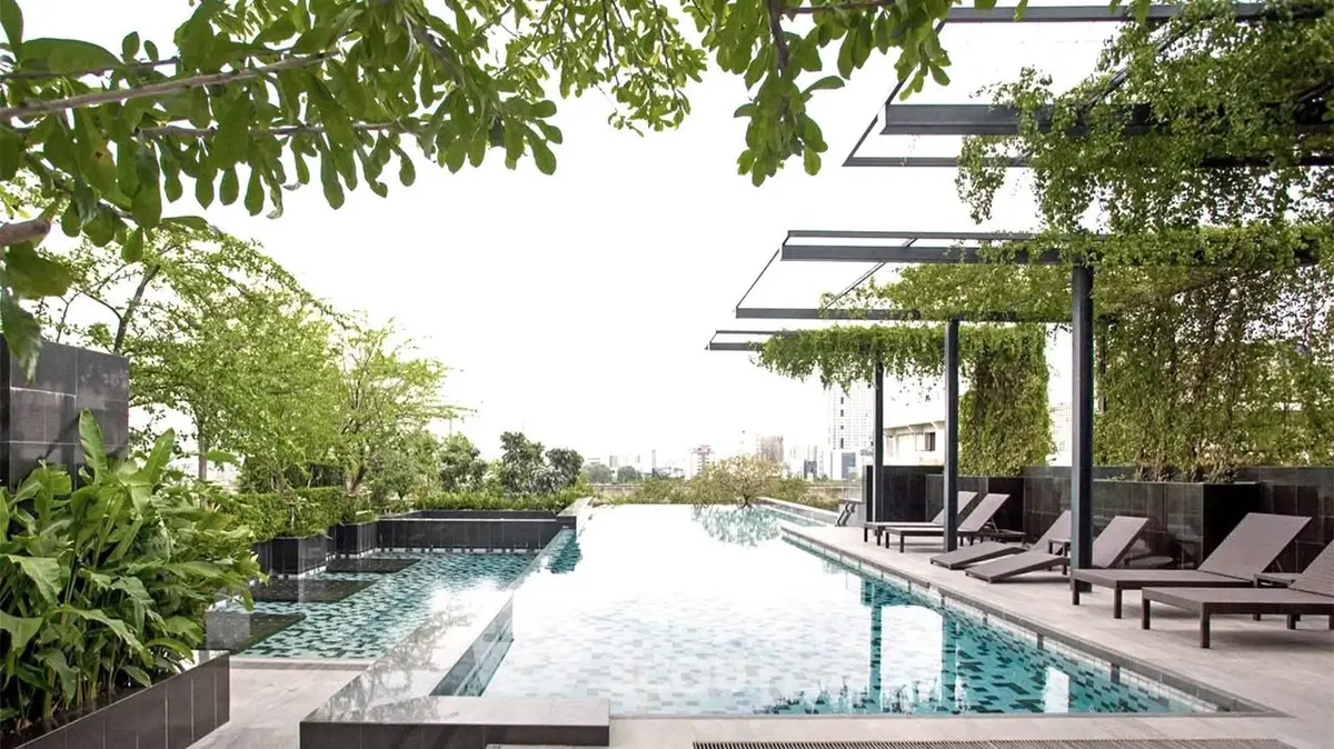 Luxurious rooftop pool with modern design and lush greenery, offering a serene urban escape.