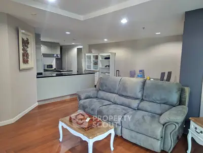 Spacious living room with modern kitchen and cozy sofa, perfect for relaxation and entertaining.
