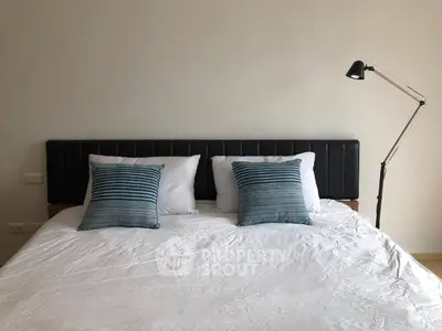 Cozy bedroom with modern decor and stylish lighting, perfect for relaxation.