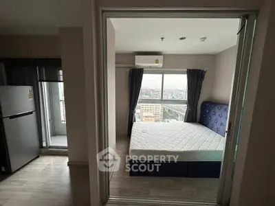 Modern bedroom with city view and balcony access in high-rise apartment