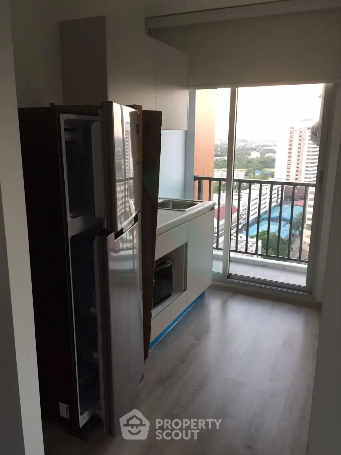Modern kitchen with balcony view in high-rise apartment