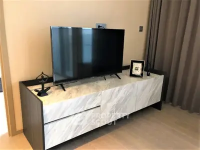 Modern living room with sleek TV stand and flat-screen TV, perfect for entertainment.