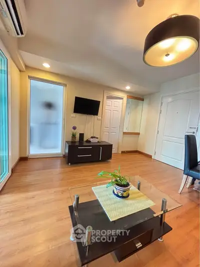 Modern living room with wooden flooring, stylish furniture, and ambient lighting.