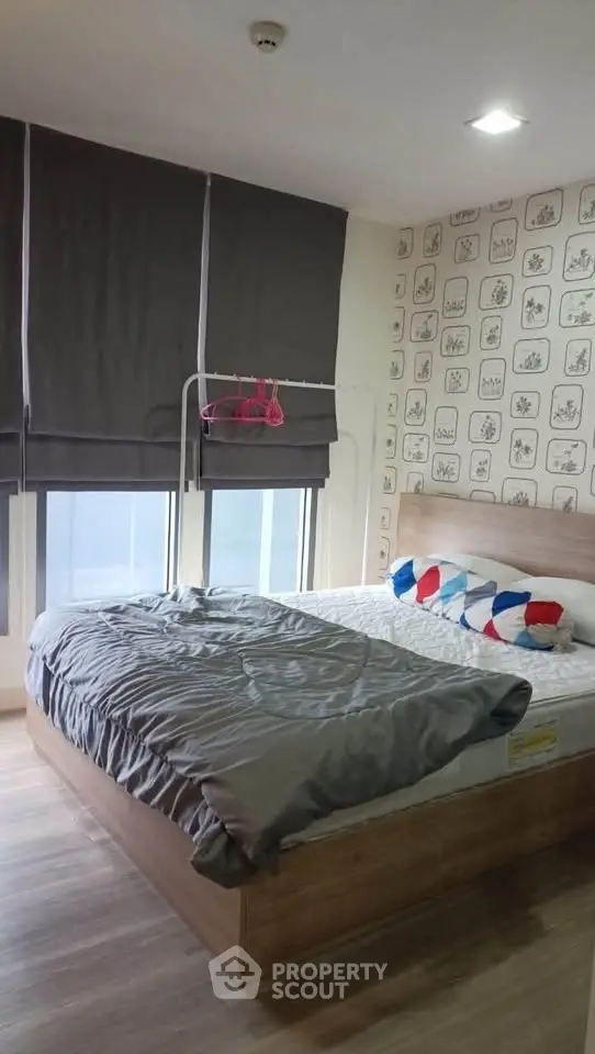 Cozy bedroom with modern decor and ample natural light, featuring stylish wall art and comfortable bedding.