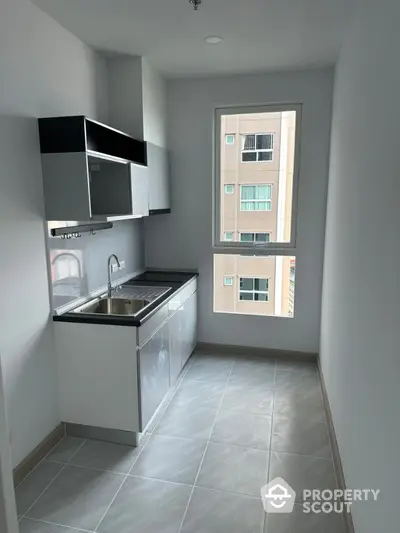 Modern compact kitchen with sleek cabinetry and large window view