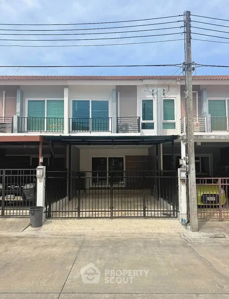 Modern two-story townhouse with gated parking and balcony, ideal for urban living.