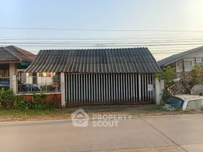 Charming single-story home with a rustic exterior and spacious front yard, perfect for renovation or investment.