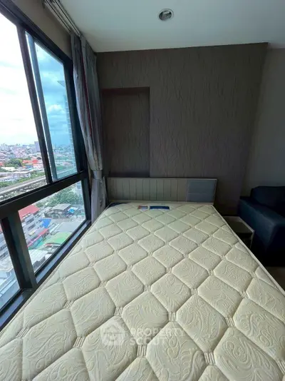 Cozy bedroom with large window offering stunning city views, featuring a comfortable bed and modern decor.