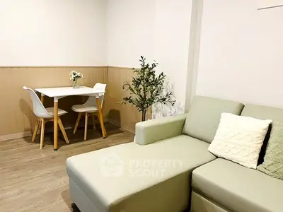 Cozy living room with modern sofa and dining area, perfect for relaxation and entertaining.