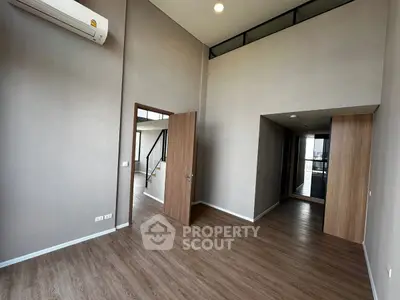 Spacious modern interior with high ceilings and wooden flooring, ideal for contemporary living.