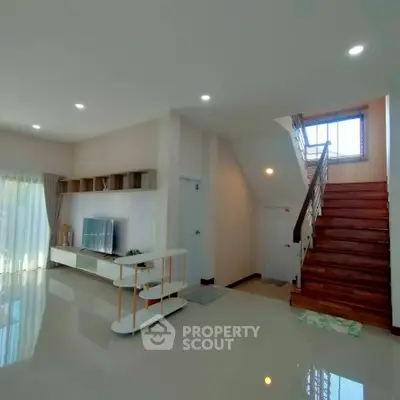 Spacious modern living room with elegant staircase and natural light