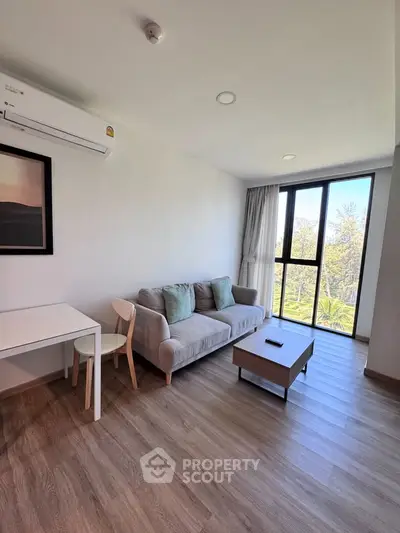 Modern living room with large windows and stylish furniture, offering a bright and inviting atmosphere.