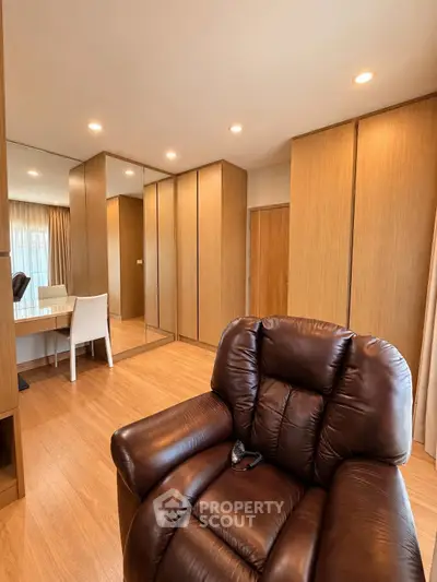 Spacious living room with luxurious leather recliner and elegant wooden cabinetry