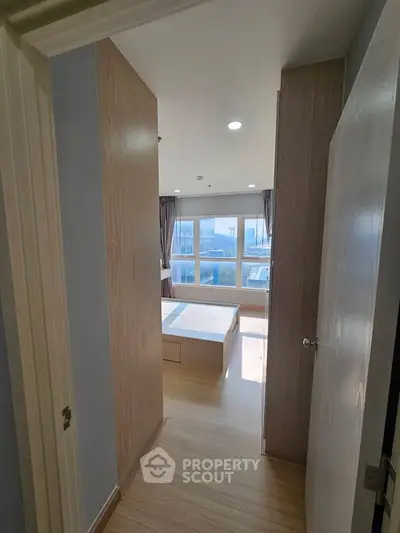 Bright and airy bedroom with large windows and modern wooden flooring, perfect for a cozy living experience.