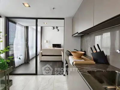Modern open-layout kitchen with sleek design and view into stylish living room