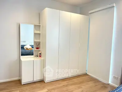 Modern bedroom with sleek white wardrobe and vanity mirror